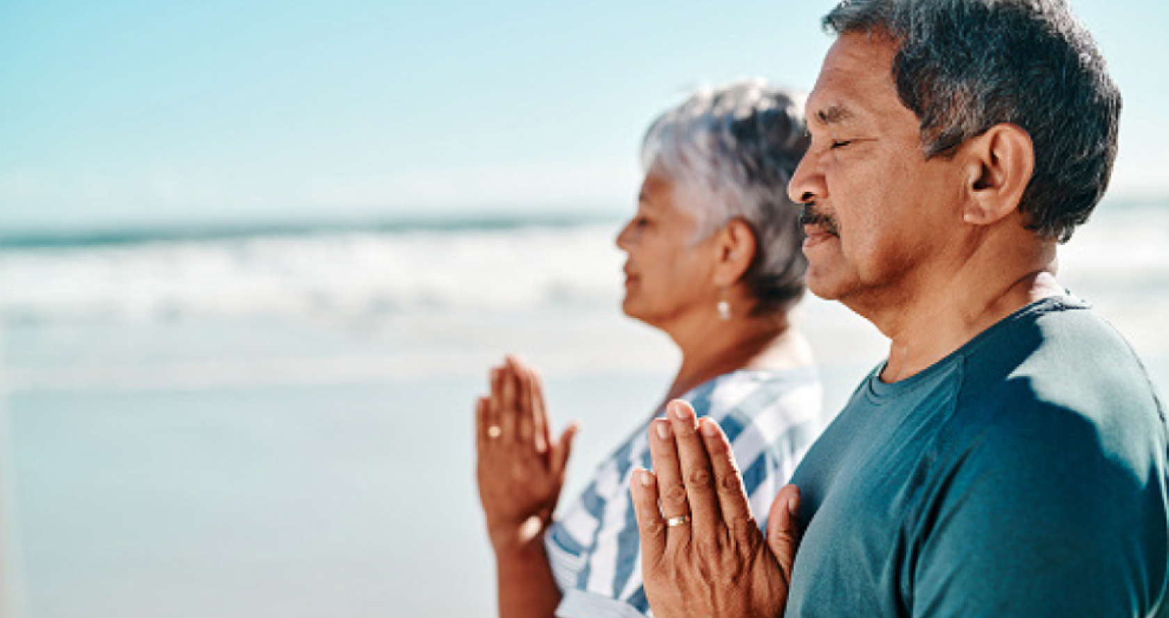 Older adult man and woman doing yoga outside to cope with stress