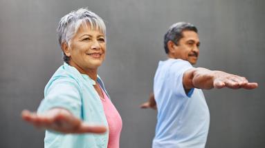 Older couple doing yoga to improve their balance