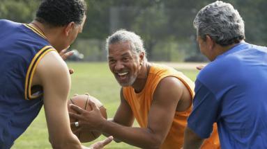 Older adult men playing basketball outside